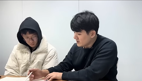 김윤건 선생님이 학생 옆에서 개별 지도하는 모습
